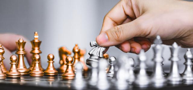 Hand of businessman play chess game